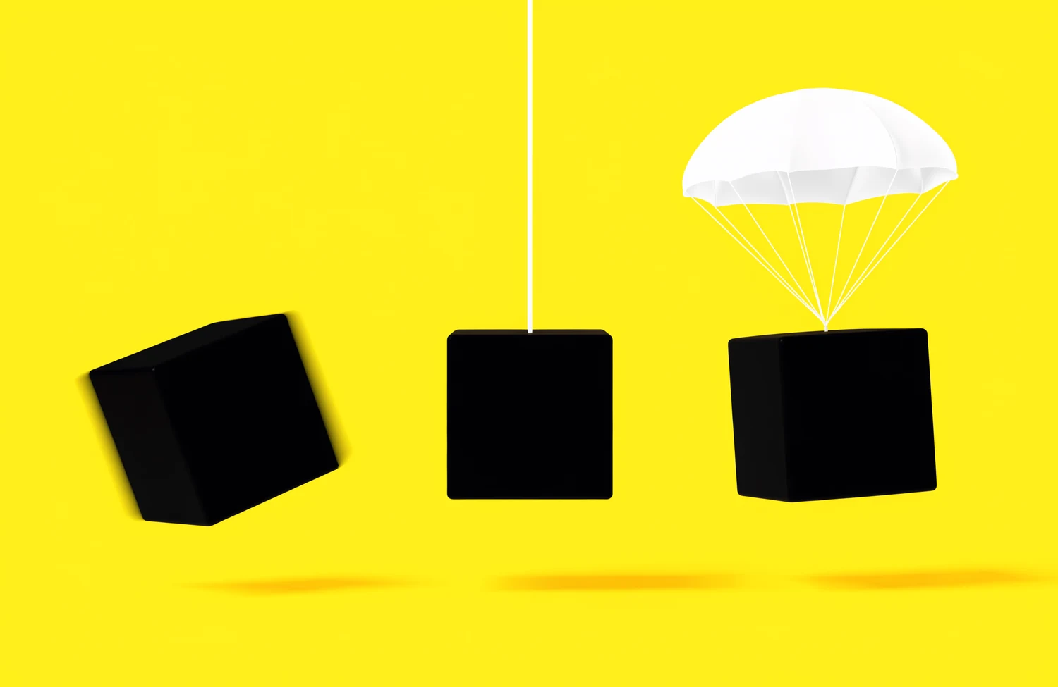 Three black cubes: one falling free, one on a cord, one under a parachute